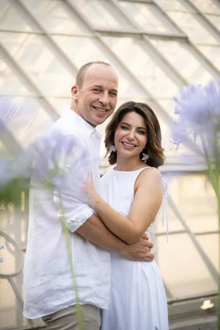 Luca and Nasrin, in a sunlit glass greenhouse